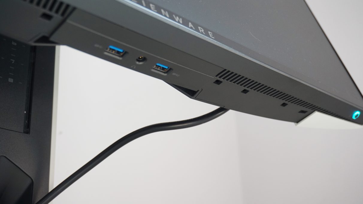 Una foto que muestra dos de los puertos USB 3.0 del Alienware AW2521HFL y el conector para auriculares en el bisel inferior de la pantalla principal.