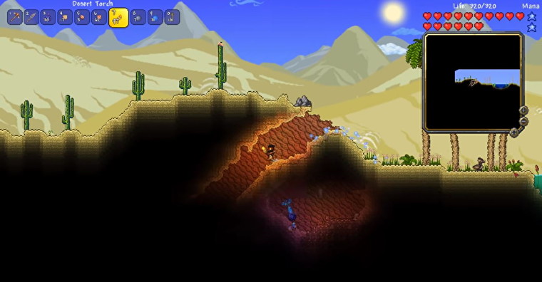 Una imagen de Terraria que muestra al personaje del jugador en un bioma del desierto.  Están sosteniendo una antorcha mientras descienden a un túnel oscuro e inexplorado. 