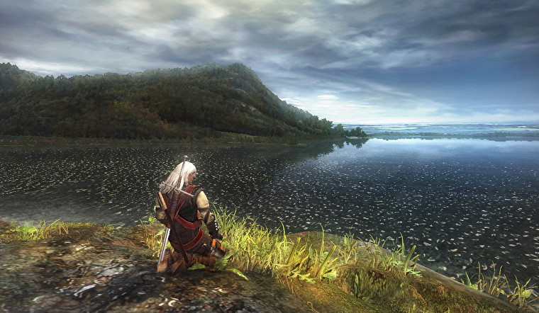 Geralt de The Witcher se arrodilla en una orilla cubierta de hierba con vistas a un enorme lago, con una montaña en la distancia.  Es bonito, para 2007.