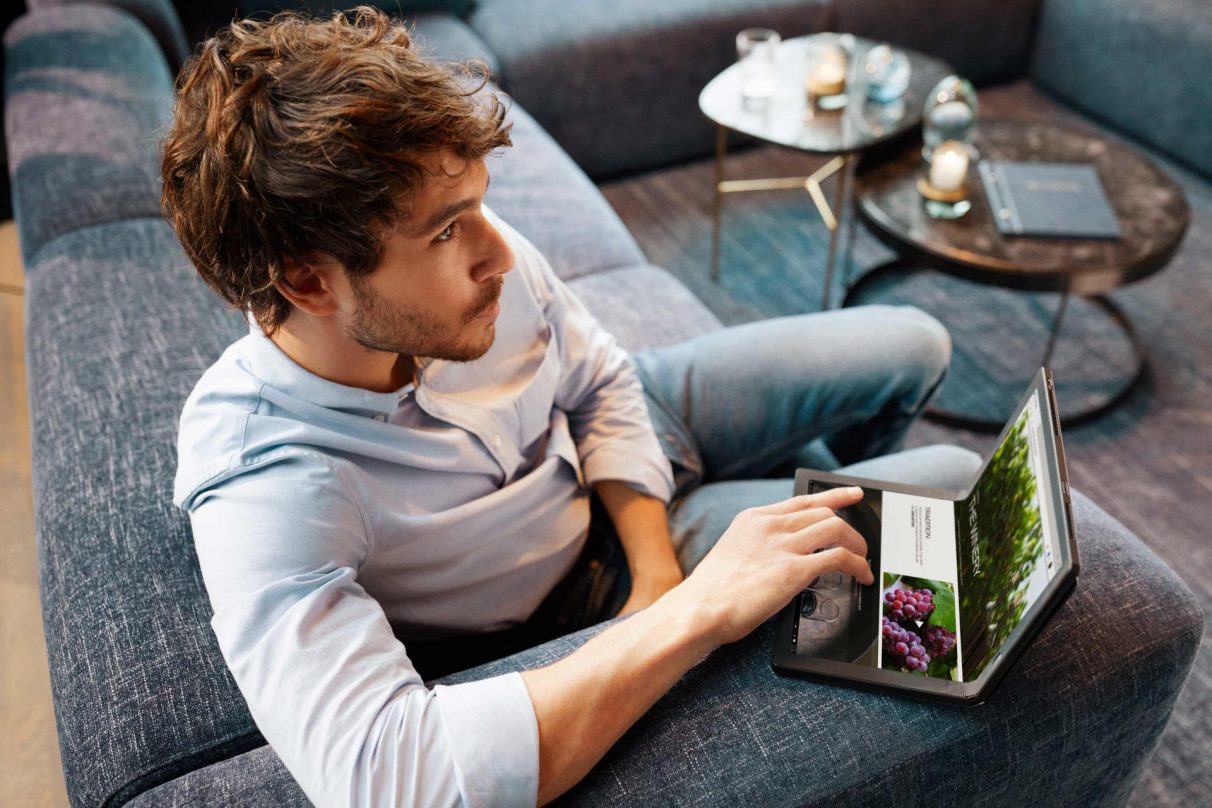 Un hombre contempla el vino en una foto de 'estilo de vida' del Lenovo ThinkPad X1 Fold.