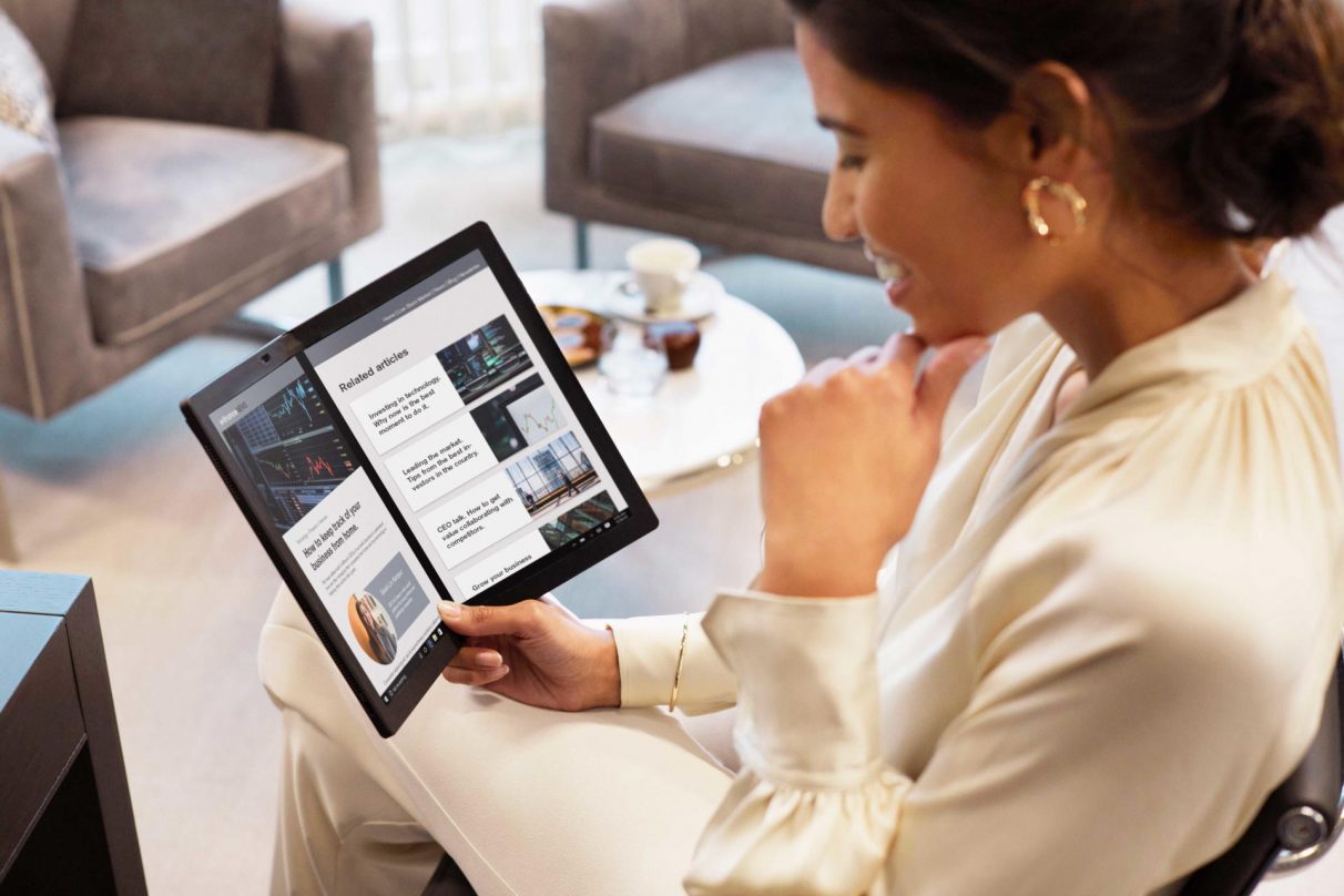 Una mujer disfruta del vino de negocios en una foto de 'estilo de vida' del Lenovo ThinkPad X1 Fold.
